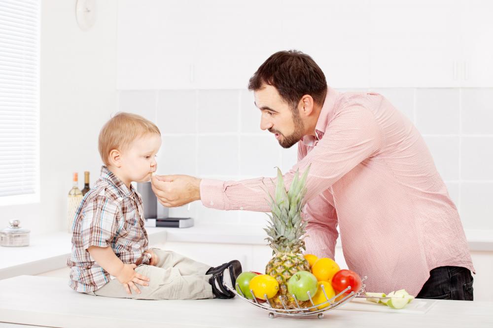 Father feeding child in kitchen