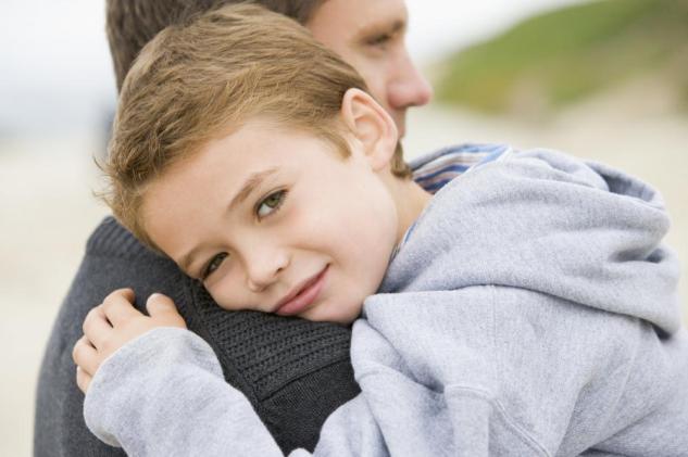 Father holding son at beach